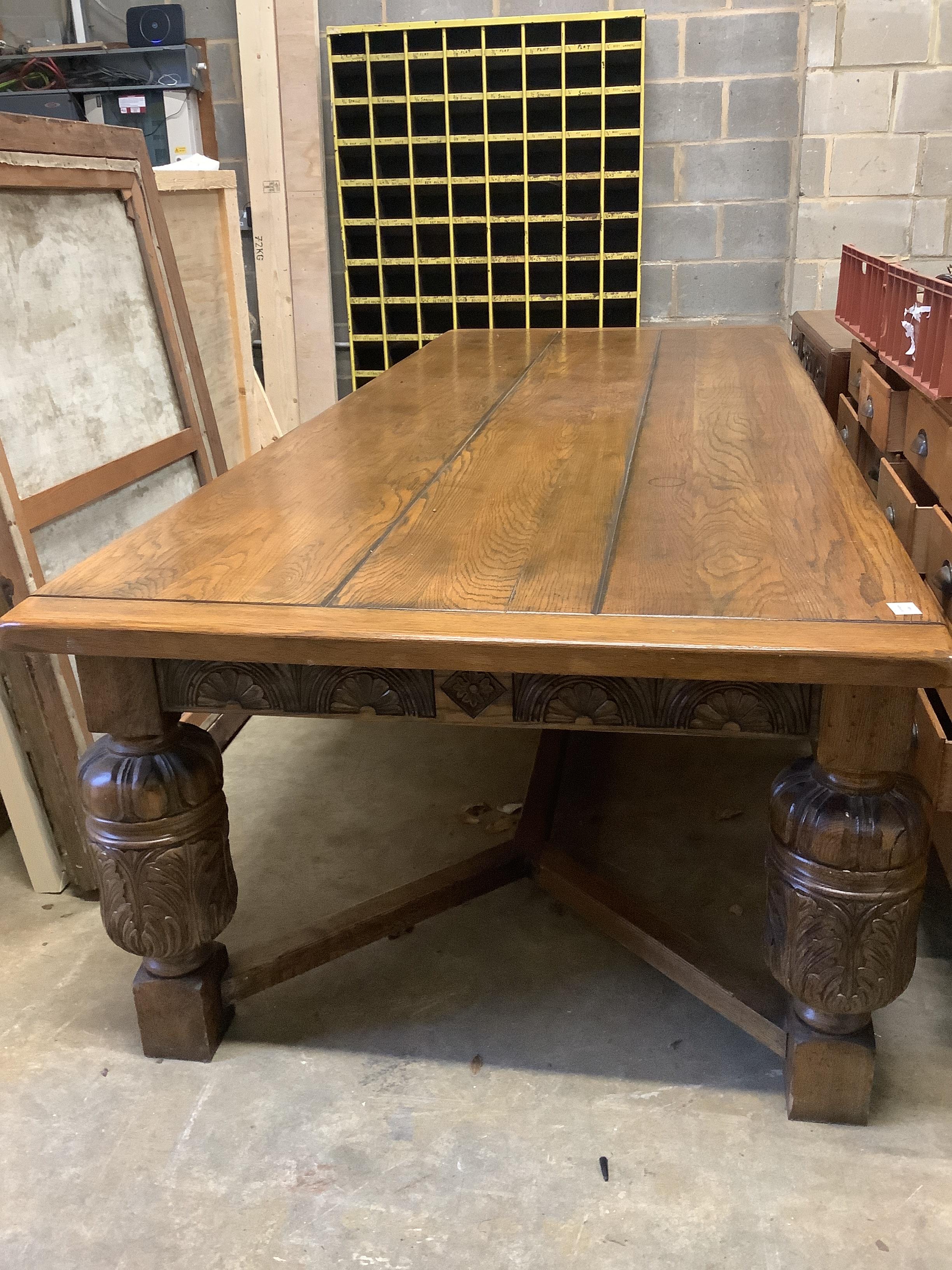 A very large 17th century style oak refectory dining table, with cleated three plank top on carved baluster legs, length 305cm, depth 120cm, height 76cm